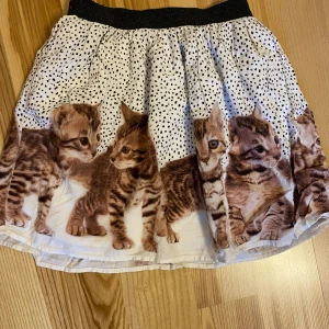 Kjol strl 134/140 - Såååå söt kjol med katter på! Kolla gärna in mina andra annonser för samfrakt. Jag är väldigt mån om mina köpare. Skulle du vara missnöjd med ditt köp så ta gärna kontakt med mig innan dåligt omdöme, så har jag en chans att rätta till det.