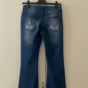 Jeans med rosa kronor som liknar de från Victoria Beckham, köpta här på plick och har inga defekter. Innerbenslängd: 67 cm midjemått: 78 cm💗💗