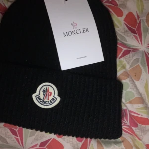Moncler mössa - De är en unisex mössa den är perfekt för vintern den är i ny skick aldrig använd fick den av min farfar. I ny skick går den för 2250 