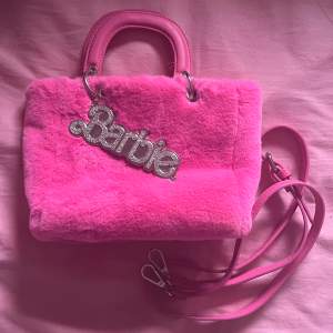Jättefin fluffig Barbie X Skinnydip London väska! Använd 2-3 ggr bara, i fint skick och har inga defekter 🫧 Liten i storleken, rymmer typ mobil + accessoarer 🩷 200 kr + frakt, tar bara köp nu!