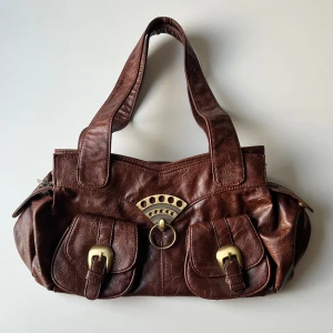 Brun väska - Brun vintage handväska från Hucu Vip. Längd: ca 35-40 cm. Bredd: ca 21 cm. Djup: 11 cm 💕