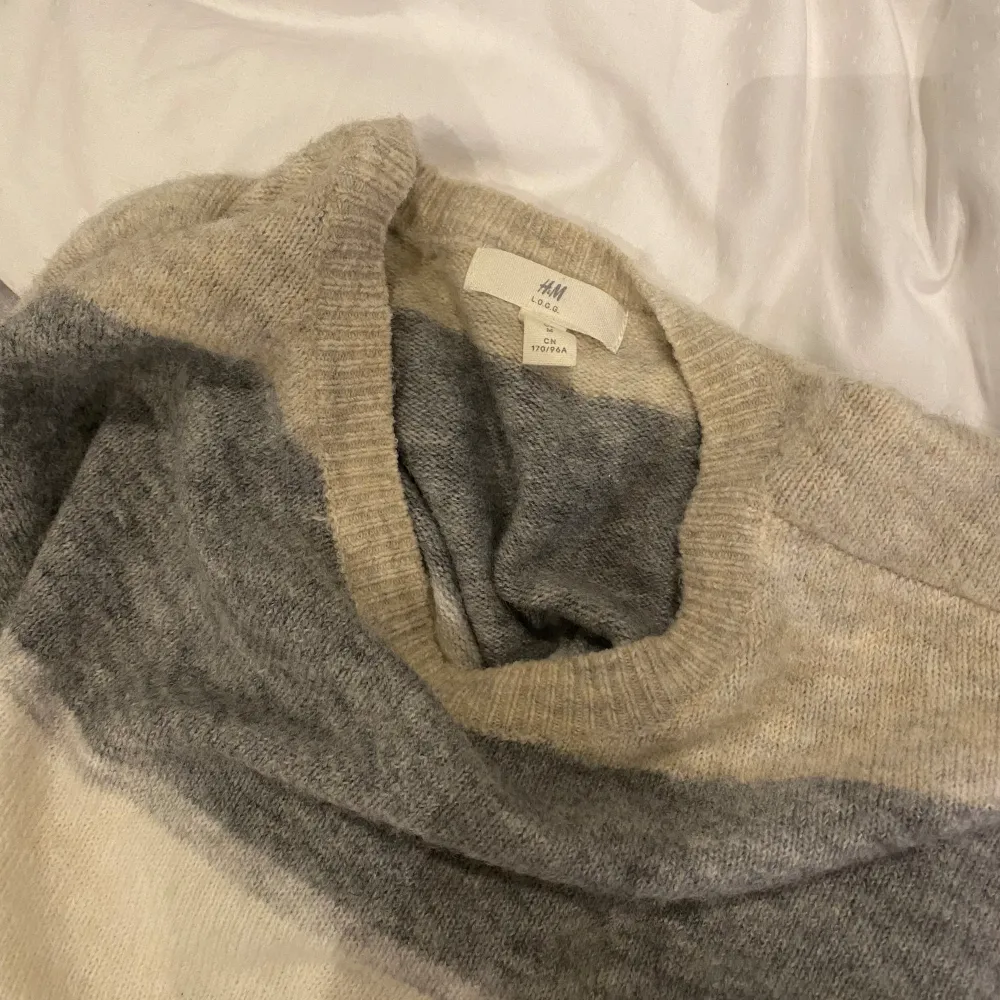 Stickad randig tröja i beige, grått och vitt från H&M. Jättefint skick, i strl. M. Tröjor & Koftor.