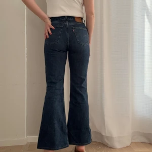Levi’s 70s high flare - Mörkblå 70s High flare från Levi’s. Storlek W26 L34, dock uppsydda så dem är tyvärr för korta för mig som är 172 cm. Passar nog bra längdmässigt på någon som är runt 165 eller kortare. I bra skick förutom en liten reva på ena benet (bild kan skickas)