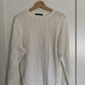 Mysig, avslappnad tjock kabelstickad drop shoulder-tröja i vit från Brandy Melville. Den är i bra skick, endast använd 3-4 gånger och är one size.  Ursprungligt pris: 38$ (US-dollar) Obs: köparen står för frakten!