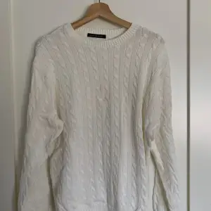 Mysig, avslappnad tjock kabelstickad drop shoulder-tröja i vit från Brandy Melville. Den är i bra skick, endast använd 3-4 gånger och är one size.  Ursprungligt pris: 38$ (US-dollar) Obs: köparen står för frakten!