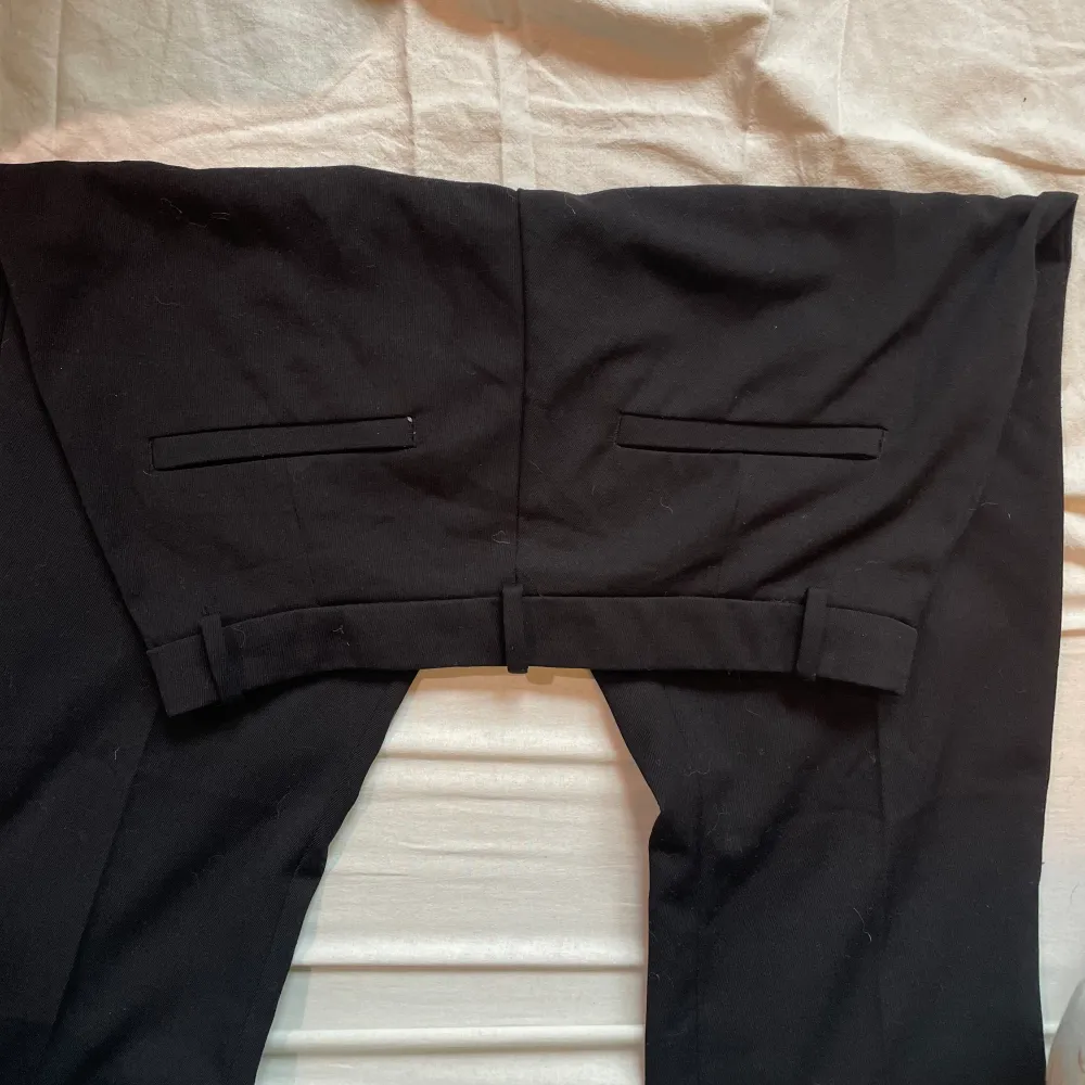 Svarta kostymbyxor med fickor, modellen ”Fiona” i fint skick. Knapp, blixtlås och plats till bälte. Sköna på sommaren.. Jeans & Byxor.