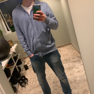 100% kashmir Soft goat zip hoodie - 100% Kashmir Zip hoodie från soft goat. Tröjan är sparsamt använd och i väldigt fint skick, inga defekter eller liknande. Inte så tjock så perfekt till vår och sommar, säljer på grund av att den ej kommer till användning. Är storlek L/M