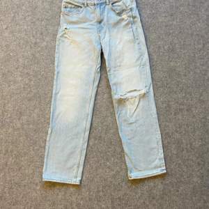 Ljusblå denim straight ripped jeans med med 4 fickor och en liten ficka 
