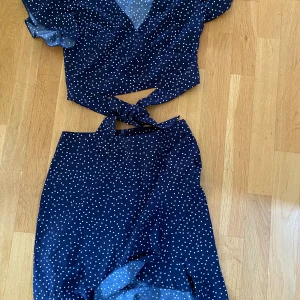 Kjol och blus  - SHEIN  XS Marinblå med vita prickar Volang längst ner på kjolen Banden på blusen knyts bak eller fram