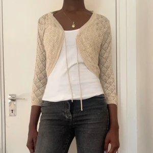 Kort glittrig beige cardigan - Den här cardigan är från H&M och har storlek M. Tyvärr måste jag säga adjö till den här vackra plagget som var en riktig favorit eftersom den börjar kännas lite tajt runt armarna. Sista bilden visar hur mönstret ser ut in zoomat. 