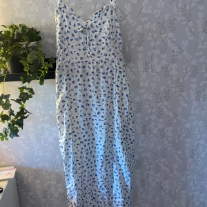 Blommig klänning från newyorker  - Vit klänning med blåa blommor ifrån newyorker. Perfekt till midsommar. Använt några gånger och är som ny. Dragskjedja på kanten som inte syns💓kontakta för fler frågor. 