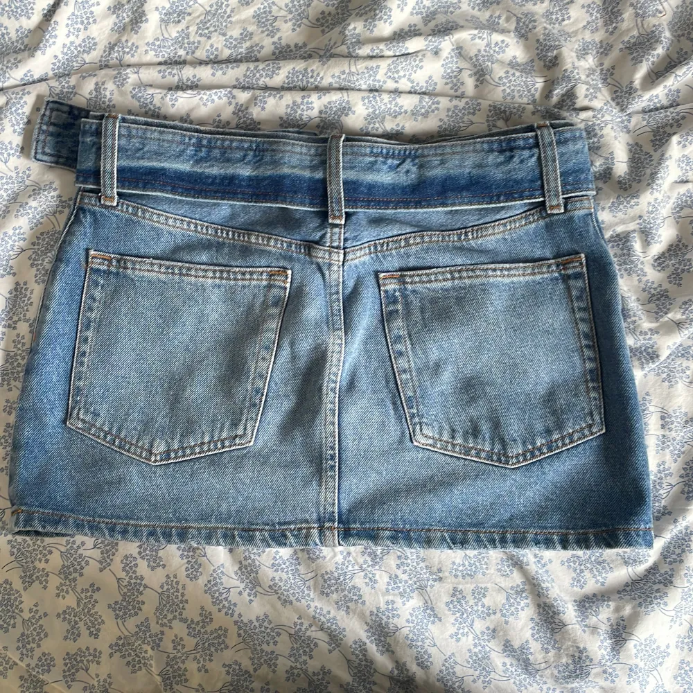 Supersnygg lågmidjad jeans kjol från secondhand! I fint skick men en bra sak att veta är att den lilla metallpinnen (bild 4) sitter lite löst så om man spänner kjolen för hårt så kan den trilla av men den kan sättas dit igen💕Den har ett egengjort hål. Kjolar.