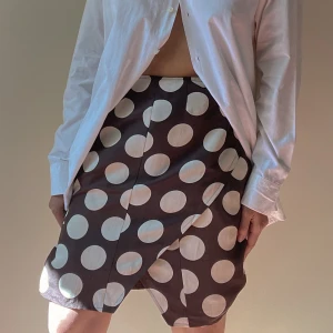 Vintage Brown Silk Wrap FlamencoDot Print Skirt - Back Zip Closure  Appears to be made by hand. Some unfinished seams in the lining-doesn't affect wear of skirt. Preloved, but still incredible  52 CM/ 20.5 IN Length, 64 CM/ 25.2 IN Waist, 84 CM/ 33.1 IN Hips