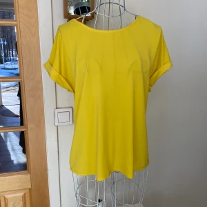 T-shirt med knappar i ryggen  - Tunn t-shorts i viskos material med dekoration knappar i ryggen