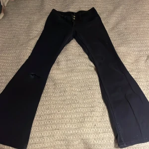 Mörkblåa lågmidjade jeans - Jättefint skick, har ett hål vid knät men det är bara snyggt! Fina detaljer vid midjan❤️