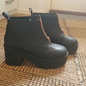 Svarta platåskor med dragkedja - Storlek 38. Svarta platåskor med dragkedja. Använda en gång. Man blir låååång när man har dessa skor på sig. 