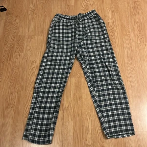 Pyjamasbyxor  - Säljer ett par snygga pyjamasbyxor som har ett rutatmönster med lite inslag av mörkgrön samt vit! Har använt de 3 gånger och det är i väldigt bra skick. Köpte de från dressman och storleken är S/M