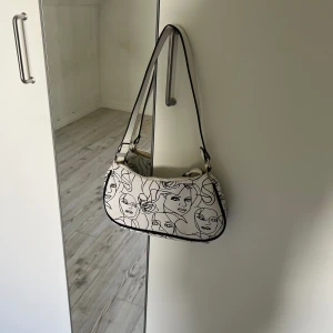 Vit väska  - En vit väska med svarta detaljer, näst intill oanvänd! 