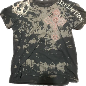 Affliction tröja - Kan skicka mer bilder på tröjan vid efterfrågan   Tröjan är i bra skick men har två hål på ena ärmen och ett hack i kragen, och rhinestones är borta