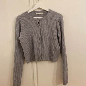 Grå kofta  - Jag säljer en grå stickad kofta som är ifrån lager 157, jag har endast använt tröjan en gång. 