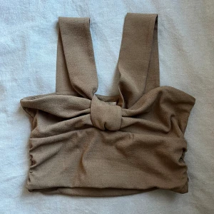 brun rosett topp - brun topp från hm. aldrig använd. strl M. nice till fest! 