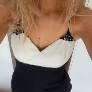 Långklänning - Så fin lång svart och vit klänning. Unik med snygga detaljer. Den är figursydd och har slits i fram, jag skulle säga att den är storlek m men även s. Märket är lite svårt att läsa men tror det är isiz minekki. Tveka inte att skriva i dem om frågor mm