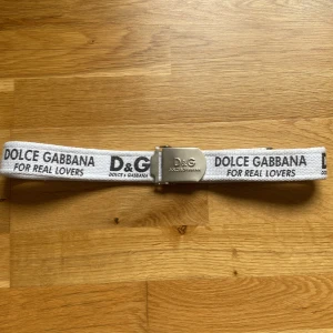 Dolce Gabbana bälte/skärp - Dolce gabbana ”for real lovers” bälte  Hyvsatt skick, liten fläck vid insidan av bältet (ej synligt) 105 cm långt/ 4cm brett silverfärgad spänne Hör av er för mer information🙌 