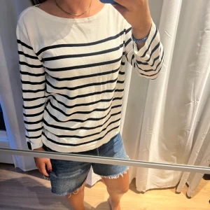 Randig tröja - Vit/blå randig tunn stickad tröja. Med trekvartsärm. Väldigt fin under sommarkvällar eller på våren. Storlek L men passar mig som är en S