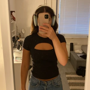 T-shirt  - Svart ribbad t-shirt med utskärning vid brösten, sitter jättefint 