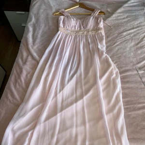 Rosa/ vit klänning / festklänning  - Färgen på den är rosa och vit den har även någon fin design vid bröstet. Den är i storlek 38.  Finns i värsta Stockholm 