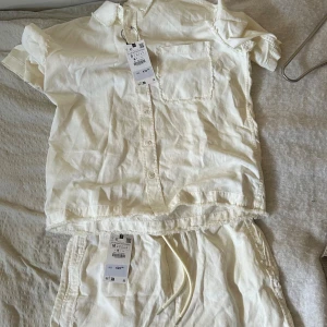 Zara sett - Oanvänt, nytt  Krämvit sett med kortärmad skjorta i storlek S och matchande shorts i storlek M från Zara.   Lite fläck på skjortsen men de ser ut att gå bort i tvättmaskin 