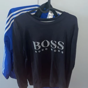 Hugo boss tröja - Säljer den här tröjan för att jag rensar min garderob. skick 8/10 för att texten på tröjan håller på låstan lite lätt på hörnen men det är inte så mycket att man ser d. Hör av er vid fråger