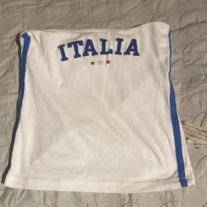 Fin tubtopp med tryck💗 - Vit tubtopp med Italia tryck på. På sidorna så är det blå streck (se bild 5). Väldigt bra skick. Köpt i en affär som inte finns i Sverige så väldigt unik. Storlek  XS men ja har vanligtvis det och den är väldigt kort på mig. Fråga gärna om du undrar