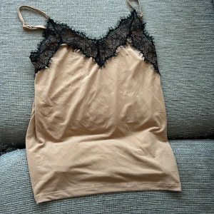 Linne  - Spets linne i beige en liten fläck men syns knappt när man har på sig linnet se bild nr 2 