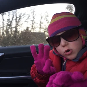 Flerfärgad mössa med ränder - En flerfärgad mössa med ränder i rosa, orange och lila. Mössan är stickad och ser varm och bekväm ut.