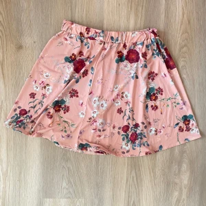 Kjol  - Snygg blommig kjol i gott skick  Cirkelskuren och har snyggt fall 