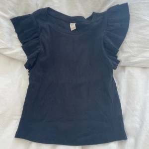 Topp med volang armar - Topp med volanger vid sidorna i storlek 158-164 men passar som xs/s
