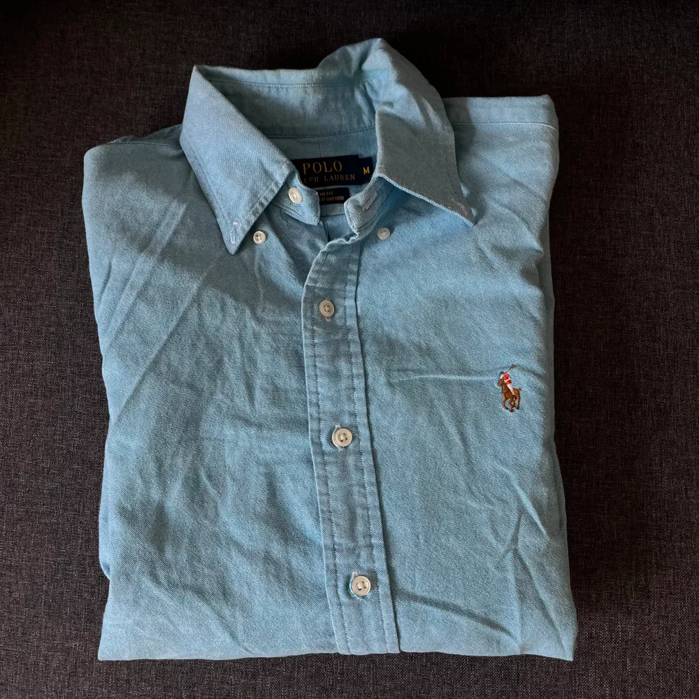 En ljusblå sommarskjorta i storlek M . Skjortor.