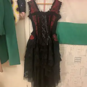 Svart och röd corset klänning. Storlek XS/S. Har använts 2 gånger, nästan helt ny och oanvänd. Kan skicka fler bilder om det begärs!