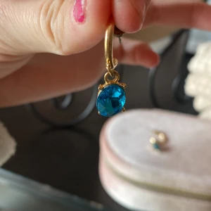 Jättefina guld örhängen! - Guldiga örhängen med en blå kristall🥰