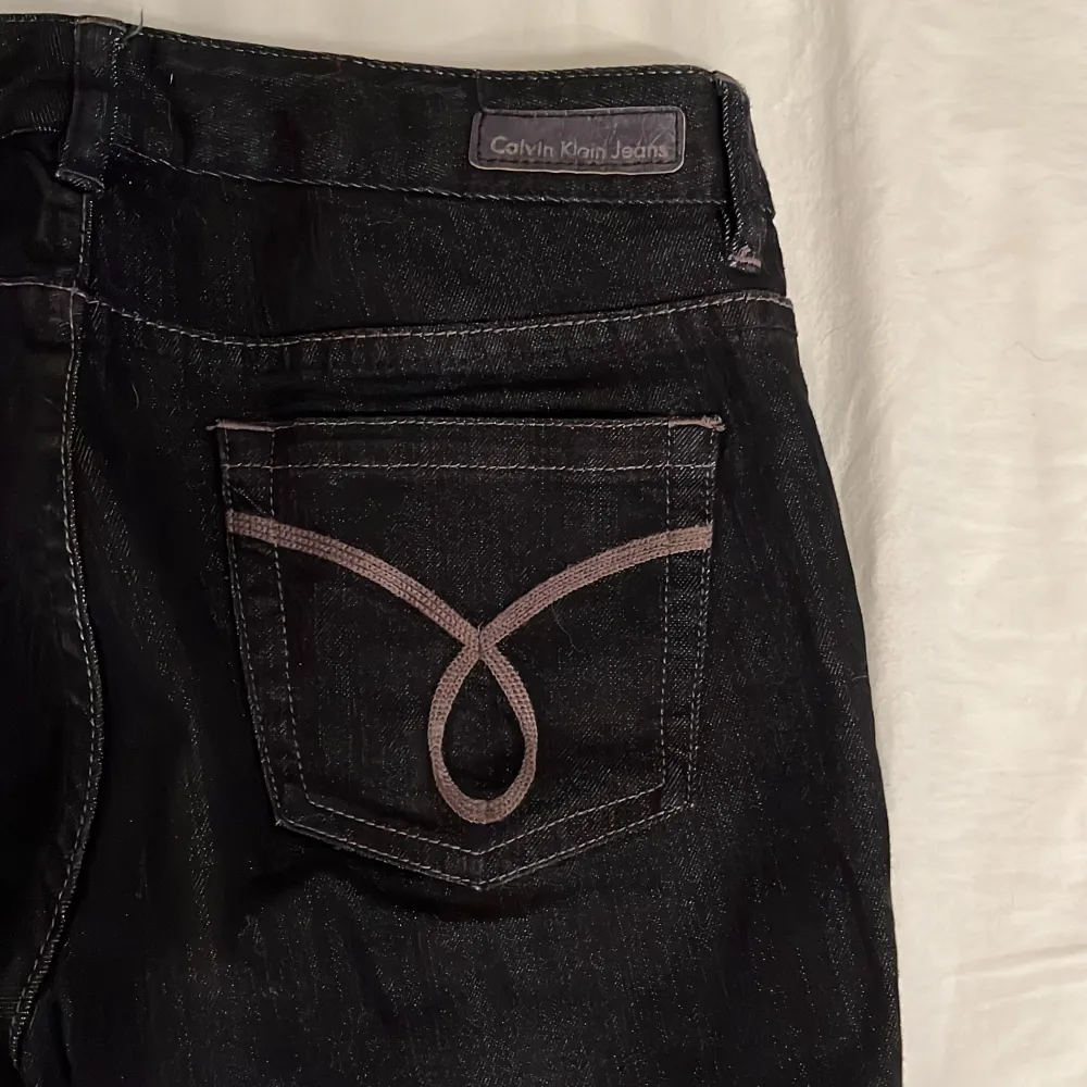 Svarta Calvin Klein lowwaist bootcut jeans. De är gamla och har klippts av lite vid benen så super bra ifall man är lite kortare! De är dock alldeles för stora för mig. . Jeans & Byxor.