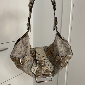 2000s Guess väska - Skitsnygg väska från Guess med 2000s vibe!! I princip perfekt skick förutom två ytterst små ljusgrå fläckar på remmen(skickar gärna bild). Kolla gärna in mina andra annonser!!