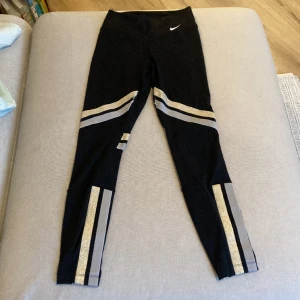 Nike tights - Träningstights från Nike. Använda men har mycket kvar att ge. Små slitningar på insida lår där glittret fäster vilket syns på bild 3 men har svart tyg under så påverkar inte användningen av byxorna.