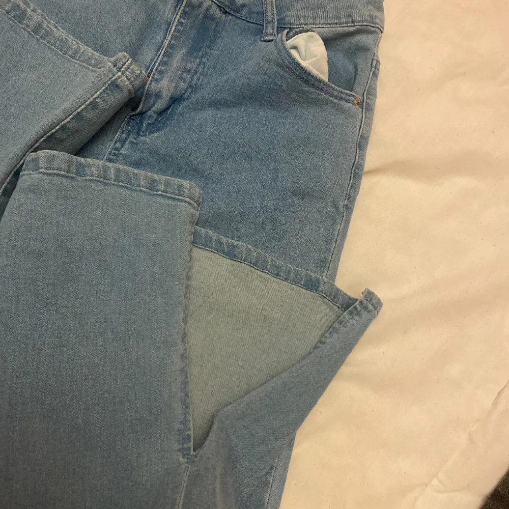 Utsvängda jeans med splitt och hål på knät. Små i storleken . Jeans & Byxor.