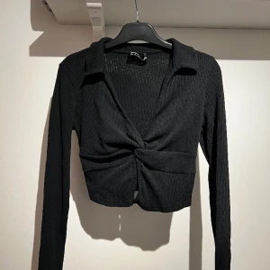 Tröja - Långärmad tröja med krage. Knytning vid brösten. Väldigt fin och sitter fint på. Bra skick. 