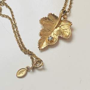 Vackert guldfärgat halsband från Avon  Ett löv med vit rhinestone 