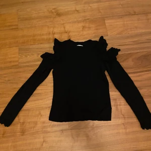 Svart långärmad med flurr  - Säljer dendär jättefina svarta långärmade tröjan med rufflade axlar🖤Storleken är M men funkar jättebra som xs. 