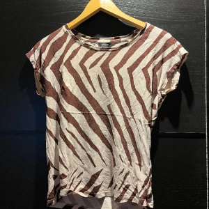 T-shirt  - T-shirt från Lindex i beige och brun.