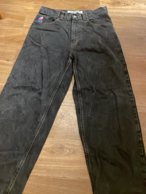 Svarta wide jeans från Big Boy - Säljer ett snygga par svarta jeans från Big Boy i storlek S. Modellen är wide med raka ben och klassiska kontrastsömmar i orange. Jeansen har fem fickor och en blå etikett bak i midjan. Perfekt för dig som gillar loose fit och streetstil. På midjan sitter dom som 31