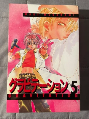 Gravitation 5 - Följ med på en fartfylld och känslosam resa i musikens och kärlekens värld! Gravitation 5 är en manga fylld av romantik, humor och drama, perfekt för dig som gillar spännande berättelser om band, rivalitet och relationer. Rekommenderas från 16 år.